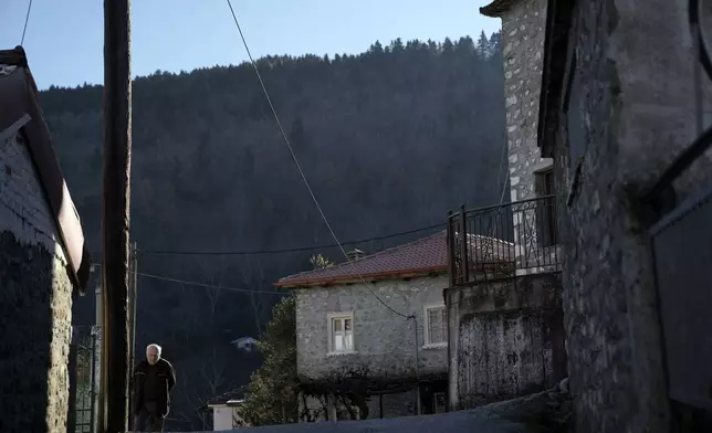 A local walks through Fourna village, central Greece, Tuesday, Nov. 26, 2024. (AP Photo/Thanassis Stavrakis)