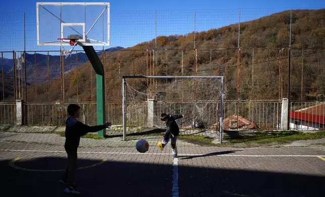 Primary school students Panagiotis, right, and Loukas play in Fourna village, central Greece, Monday, Nov. 25, 2024. (AP Photo/Thanassis Stavrakis)
