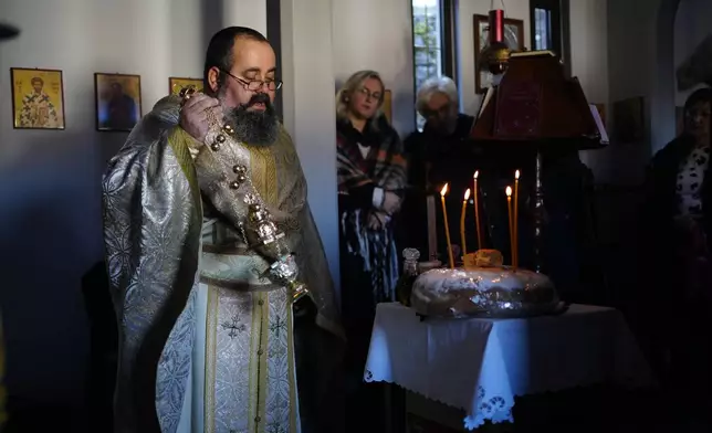 Rev. Constantine Dousikos celebrates the Blessing of the Five Loaves ceremony at the Orthodox church of Agios Stylianos in Fourna village, central Greece, Tuesday, Nov. 26, 2024. (AP Photo/Thanassis Stavrakis)