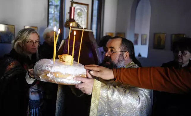 Rev. Constantine Dousikos celebrates the Blessing of the Five Loaves ceremony at the Orthodox church of Agios Stylianos in Fourna village, central Greece, Tuesday, Nov. 26, 2024. (AP Photo/Thanassis Stavrakis)