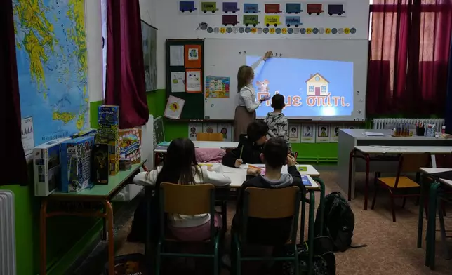 Schoolteacher Panagiota Diamanti puts magnetic letters on a board during class in Fourna village, central Greece, Tuesday, Nov. 26, 2024. (AP Photo/Thanassis Stavrakis)