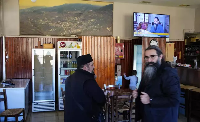 Rev. Constantine Dousikos, left, and Father Ilarion patronize a cafe in Fourna village, central Greece, Monday, Nov. 25, 2024. (AP Photo/Thanassis Stavrakis)