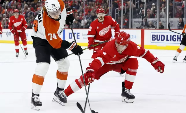 Detroit Red Wings defenseman Ben Chiarot (8) blocks a shot on goal by Philadelphia Flyers right wing Owen Tippett (74) during the second period of an NHL hockey game Wednesday, Dec. 18, 2024, in Detroit. (AP Photo/Duane Burleson)