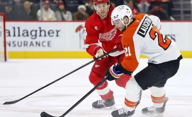 Philadelphia Flyers center Scott Laughton (21) is pursued by Detroit Red Wings defenseman Moritz Seider (53) during the first period of an NHL hockey game Wednesday, Dec. 18, 2024, in Detroit. (AP Photo/Duane Burleson)