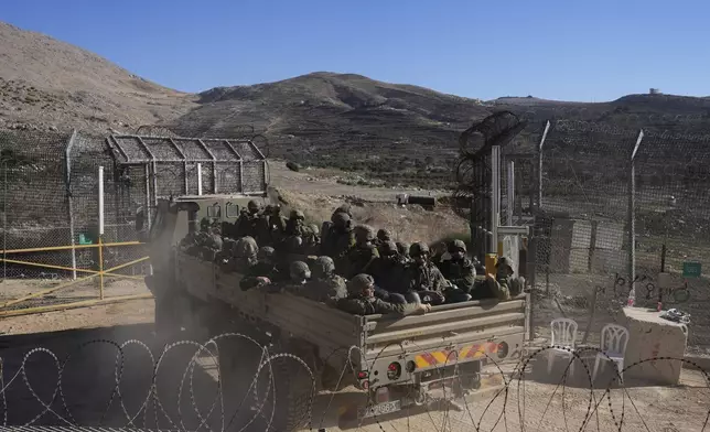 Israeli soldiers stand on an armoured vehicles before crossing the security fence, moving towards the so-called Alpha Line that separates the Israeli-controlled Golan Heights from Syria, in the town of Majdal Shams, Wednesday, Dec. 18, 2024. (AP Photo/Matias Delacroix)