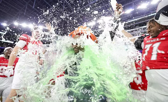 UNLV interim head coach Del Alexander is dunked after the team's victory against California during the LA Bowl NCAA college football game Wednesday, Dec. 18, 2024, in Inglewood, Calif. (AP Photo/Ryan Sun)