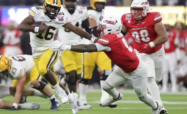 California quarterback CJ Harris, left, stiff arms UNLV linebacker Marsel McDuffie during the first half of the LA Bowl NCAA college football game Wednesday, Dec. 18, 2024, in Inglewood, Calif. (AP Photo/Ryan Sun)