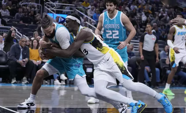 Charlotte Hornets' Cody Martin and Indiana Pacers' Pascal Siakam battle for a rebound during the second half of an NBA basketball game, Sunday, Dec. 8, 2024, in Indianapolis. (AP Photo/Darron Cummings)