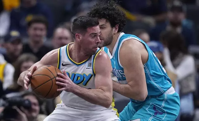 Indiana Pacers' T.J. McConnell, left, heads to the basket against Charlotte Hornets' Vasilije Micic, right, during the first half of an NBA basketball game, Sunday, Dec. 8, 2024, in Indianapolis. (AP Photo/Darron Cummings)