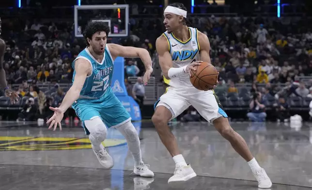 Indiana Pacers' Andrew Nembhard (2) makes a pass against Charlotte Hornets' Vasilije Micic during the second half of an NBA basketball game, Sunday, Dec. 8, 2024, in Indianapolis. (AP Photo/Darron Cummings)