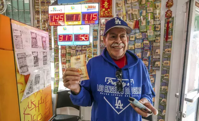 Fidel Lule buys a MegaMillion lottery ticket at Won Won Mini Mart in Chinatown Los Angeles, Thursday, Dec. 26, 2024. (AP Photo/Damian Dovarganes)