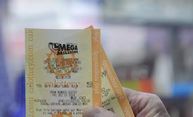 Rob holds up a Mega Millions ticket at Rossi's Deli in San Francisco, Thursday, Dec. 26, 2024. (AP Photo/Jeff Chiu)