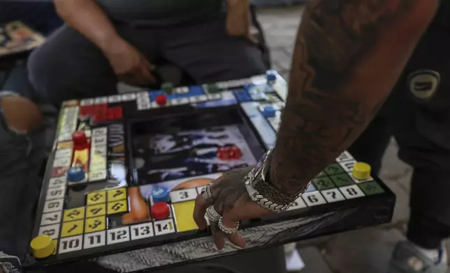 A player moves his piece in poleana, a board game invented in prison, during a tournament in Mexico City, Sunday, Nov. 17, 2024. (AP Photo/Ginnette Riquelme)