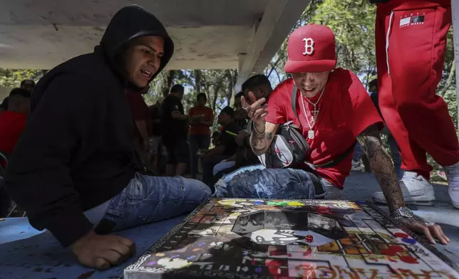 People play poleana, a board game invented in prison, before a tournament in Mexico City, Sunday, Nov. 17, 2024. (AP Photo/Ginnette Riquelme)