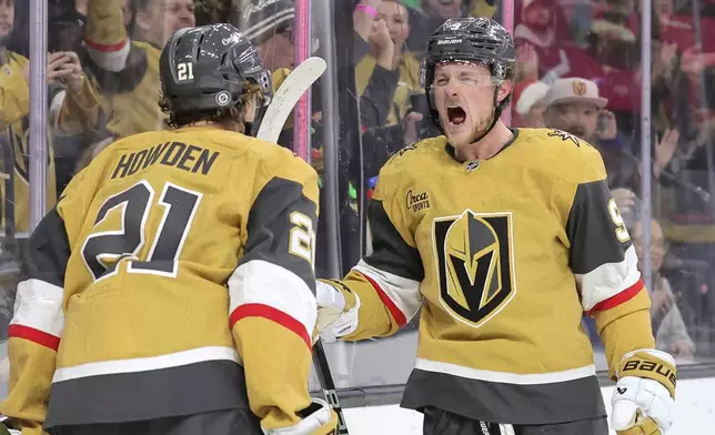 Vegas Golden Knights centers Brett Howden (21) and Jack Eichel (9) celebrate after Howden's goal against the Seattle Kraken during the first period of an NHL hockey game Saturday, Dec. 21, 2024, in Las Vegas. (Steve Marcus/Las Vegas Sun via AP)