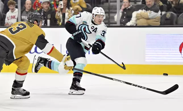 Seattle Kraken center Yanni Gourde shoots against Vegas Golden Knights defenseman Brayden McNabb (3) during the first period of an NHL hockey game, Saturday, Dec. 21, 2024, in Las Vegas. (AP Photo/David Becker)