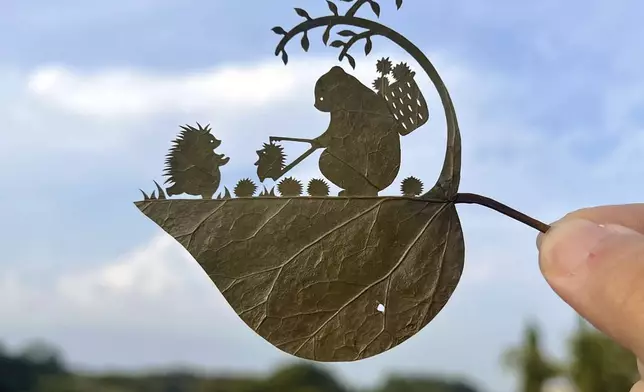 This undated photo provided by Japanese leaf-cutting artist, who goes by the name Lito, shows his work titled: "Wait a second! That's my baby!" (Lito via AP)