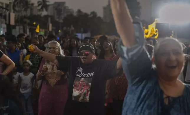 People celebrate New Year's eve at a promenade in Mumbai, India, Tuesday, Dec. 31, 2024. (AP Photo/Rafiq Maqbool)