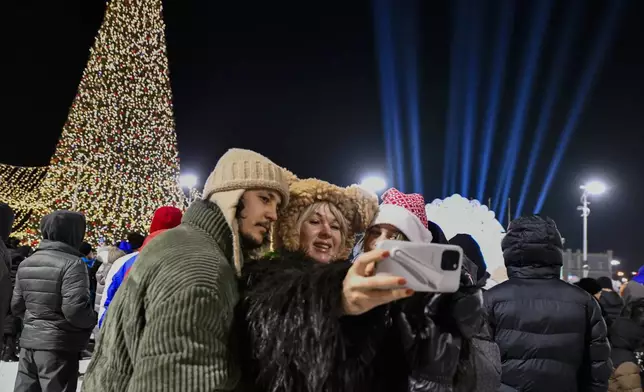 People make a selfie as they gather in the center of the Russian far east port Vladivostok, Russia, Tuesday, Dec. 31, 2024, to celebrate the new year. (AP Photo)