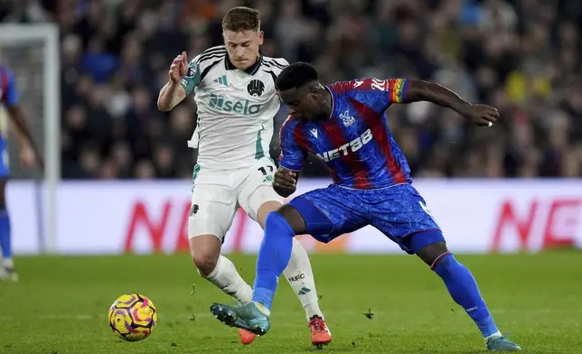 Newcastle United's Harvey Barnes, left, and Crystal Palace's Marc Guehi battle for the ball during the English Premier League soccer match between Crystal Palace and Newcastle United at Selhurst Park, London, Saturday Nov. 30, 2024. (Ben Whitley/PA via AP)