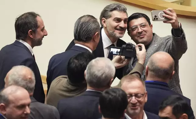 Georgian president-elect Mikheil Kavelashvili, 2nd right, poses for a selfie at the Georgian parliament, in Tbilisi, Georgia, Saturday. Dec. 14, 2024. (AP Photo)