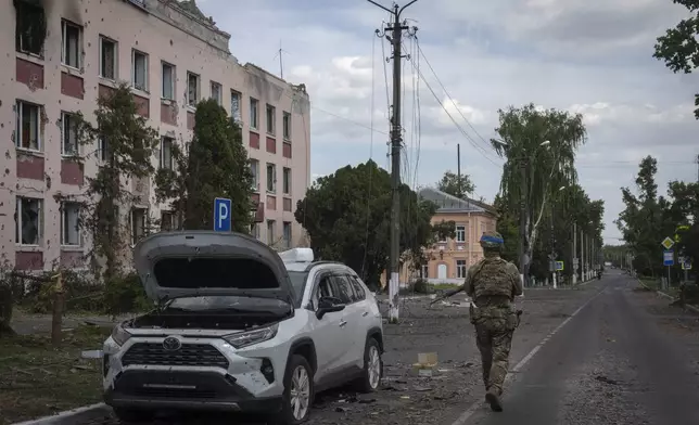 FILE - A Ukrainian soldier walks past a building in Sudzha, Kursk region, Russia, on Aug. 16, 2024. This image was approved by the Ukrainian Defense Ministry before publication. (AP Photo, File)