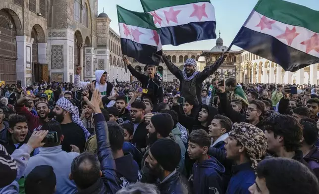 FILE - People chant slogans and wave the new Syrian flag as they gather for Friday prayers at the Umayyad mosque in Damascus, Syria, on Dec. 13, 2024. (AP Photo/Leo Correa, File)