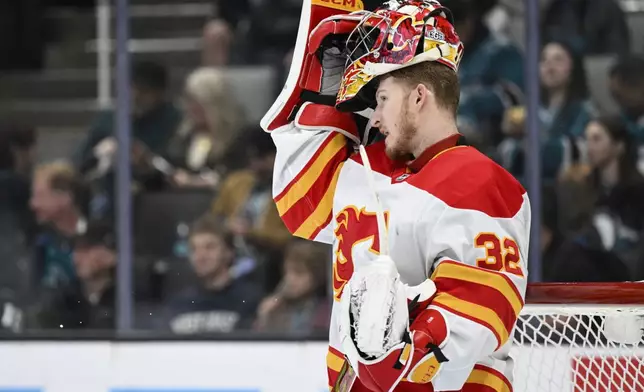 Calgary Flames goaltender Dustin Wolf stands on the ice during a break in play against the San Jose Sharks during the first period of an NHL hockey game Saturday, Dec. 28, 2024, in San Jose, Calif. (AP Photo/Eakin Howard)