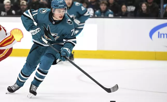 San Jose Sharks center Macklin Celebrini (71) controls the puck against the Calgary Flames during the second period of an NHL hockey game Saturday, Dec. 28, 2024, in San Jose, Calif. (AP Photo/Eakin Howard)