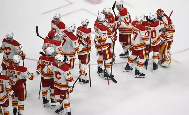 The Calgary Flames celebrate their win over the San Jose Sharks after an NHL hockey game Saturday, Dec. 28, 2024, in San Jose, Calif. (AP Photo/Eakin Howard)