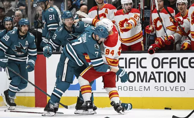 San Jose Sharks center Nico Sturm (7) and Calgary Flames defenseman Brayden Pachal (94) get in a fight during the first period of an NHL hockey game Saturday, Dec. 28, 2024, in San Jose, Calif. (AP Photo/Eakin Howard)