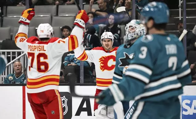 Calgary Flames center Mikael Backlund (11) celebrates his goal with center Martin Pospisil (76) against the San Jose Sharks during the second period of an NHL hockey game Saturday, Dec. 28, 2024, in San Jose, Calif. (AP Photo/Eakin Howard)