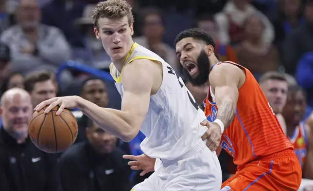 Utah Jazz forward Lauri Markkanen, left, dribbles as Oklahoma City Thunder forward Kenrich Williams, right, defends during the first half of an Emirates NBA Cup basketball game, Tuesday, Dec. 3, 2024, in Oklahoma City. (AP Photo/Nate Billings)