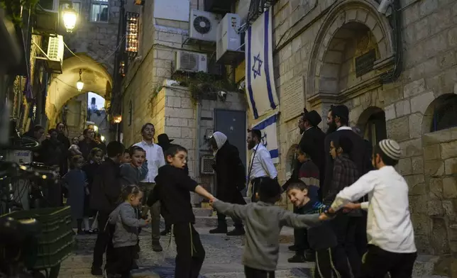 Ultra-Orthodox Jewish people dance and sing on the fifth night of Hanukkah in Jerusalem's Old City, Sunday, Dec. 29, 2024. (AP Photo/Matias Delacroix)