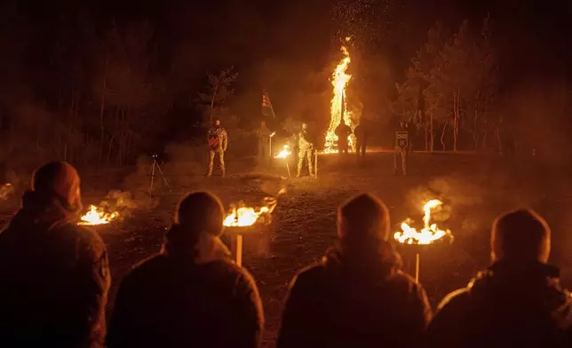 Ukrainian servicemen of 3rd assault brigade participate memorial ceremony of their fallen comrades during the winter solstice in Kharkiv region, Ukraine, Dec. 22, 2024. (AP Photo/Evgeniy Maloletka)