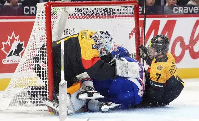 USA forward Danny Nelson (17) and Germany defenceman Carlos Handel (7) crash into Nico Pertuch's (1) net during first period IIHF World Junior Hockey Championship preliminary round action in Ottawa on Thursday, Dec. 26, 2024. (Sean Kilpatrick/The Canadian Press via AP)