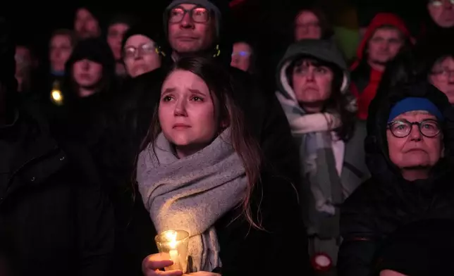 People outside Magdeburg Cathedral follow a memorial service for victims of Friday's Christmas Market attack, where a car drove into a crowd, in Magdeburg, Germany, Saturday, Dec. 21, 2024. (AP Photo/Ebrahim Noroozi)