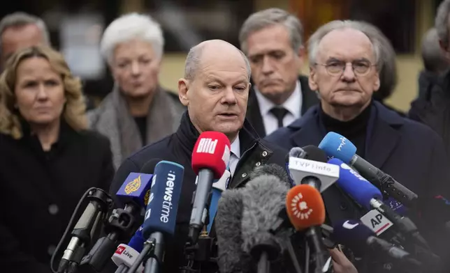 The Chancellor of Germany Olaf Scholz answers to reporters at a Christmas Market, where a car drove into a crowd on Friday evening, in Magdeburg, Germany, Saturday, Dec. 21, 2024. (AP Photo/Ebrahim Noorozi)