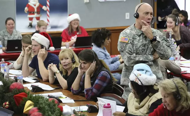 FILE - NORAD Chief of Staff Maj. Gen. Charles D. Luckey takes a call while volunteering at the NORAD Tracks Santa center at Peterson Air Force Base in Colorado Springs, Colo., Dec. 24, 2014. (AP Photo/Brennan Linsley, File)