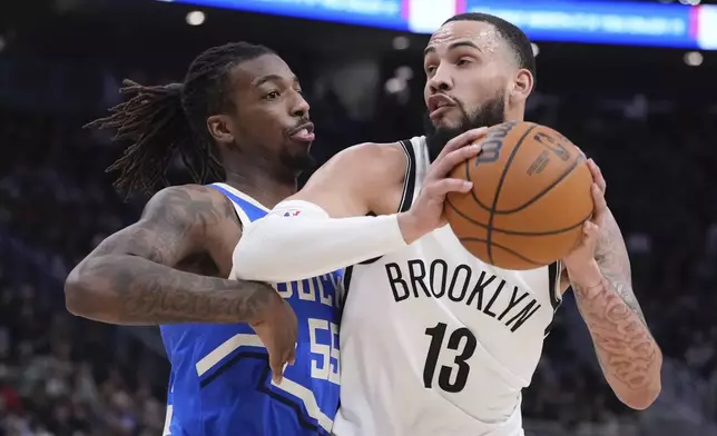 Brooklyn Nets' Tyrese Martin tries to get past Milwaukee Bucks' Delon Wright during the first half of an NBA basketball game Thursday, Dec. 26, 2024, in Milwaukee. (AP Photo/Morry Gash)