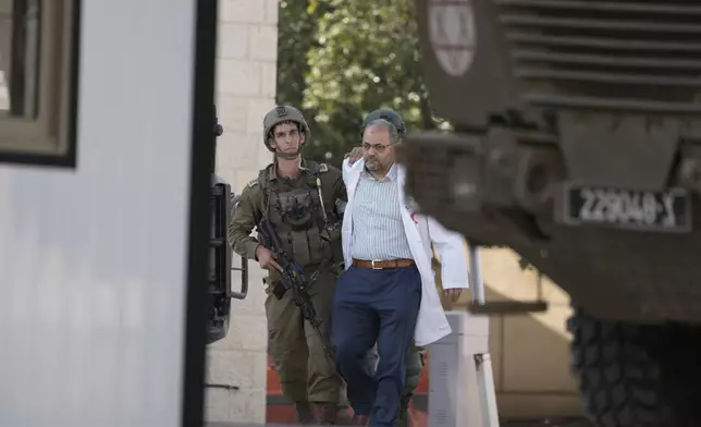 Israeli troops detain the director of the Turkish hospital doctor Mohammad Samara for interrogation before releasing him, while searching for the bodies of militants in a Palestinian hospital in the West Bank city of Tubas, Tuesday Dec. 3, 2024 (AP Photo/Majdi Muhammad).