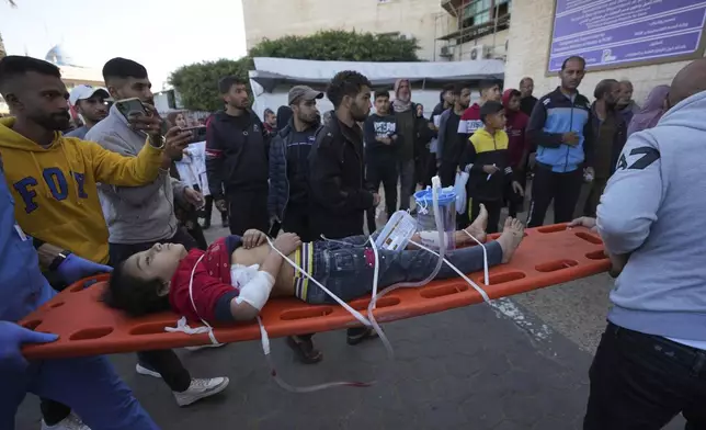 A wounded Palestinian child is carried on a stretcher at the Al-Aqsa Martyrs hospital in Deir al-Balah, following an Israeli bombardment in Nuseirat, central Gaza, Wednesday, Dec. 4, 2024. (AP Photo/Abdel Kareem Hana)