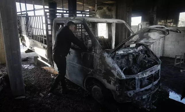 Mohammed Hanani looks at his burnt car following a settler attack that damaged vehicles and houses in the village of Beit Furik, in the occupied West Bank city of Nablus, Wednesday, Dec. 4, 2024. (AP Photo/Majdi Mohammed)