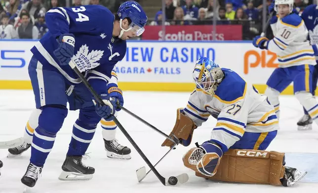 Toronto Maple Leafs center Auston Matthews (34) is stopped by Buffalo Sabres goaltender Devon Levi (27) during second-period NHL hockey game action in Toronto, Sunday, Dec. 15, 2024. (Frank Gunn/The Canadian Press via AP)