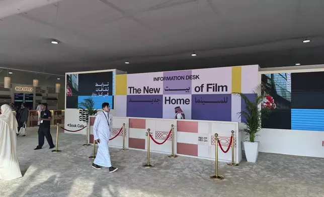 Visitors walk past the information desk at the Red Sea International Film Festival in Jeddah, Saudi Arabia, Thursday, Dec. 5, 2024. (AP Photo/Baraa Anwer)