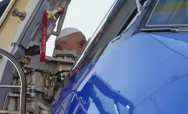 Pope Francis boards an airplane at Rome's Fiumicino, airport as he leaves for his one-day visit to Ajaccio in he French island of Corsica, Sunday, Dec.15, 2024. (AP Photo/Gregorio Borgia)