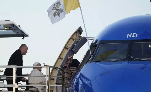 Pope Francis boards an airplane at Rome's Fiumicino, airport as he leaves for his one-day visit to Ajaccio in he French island of Corsica, Sunday, Dec.15, 2024. (AP Photo/Gregorio Borgia)