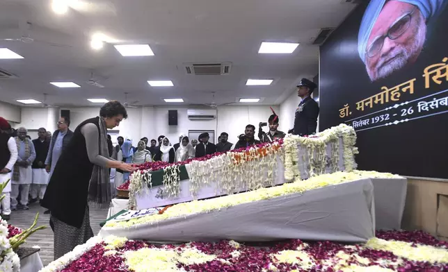 Congress Party leader Priyanka Gandhi Vadra touches the casket of former Indian Prime Minister Manmohan Singh to pay her tributes at the party headquarters in New Delhi, India, Saturday, Dec. 28, 2024. (AP Photo)