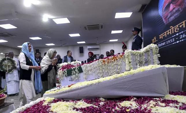 Gursharan Kaur, second left, wife of former Indian Prime Minister Manmohan Singh, prays next to the casket of her late husband to pay her tributes at the Congress party headquarters in New Delhi, India, Saturday, Dec. 28, 2024. (AP Photo)