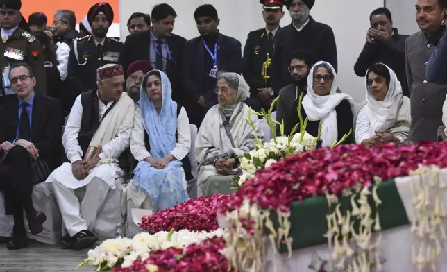 Gursharan Kaur, center right, wife of former Indian Prime Minister Manmohan Singh, sits with others next to the casket of her late husband at Congress party headquarters in New Delhi, India, Saturday, Dec. 28, 2024. (AP Photo)